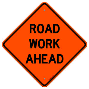 Señalización vial en naranja que contiene el mensaje "trabajo en la carretera más adelante"